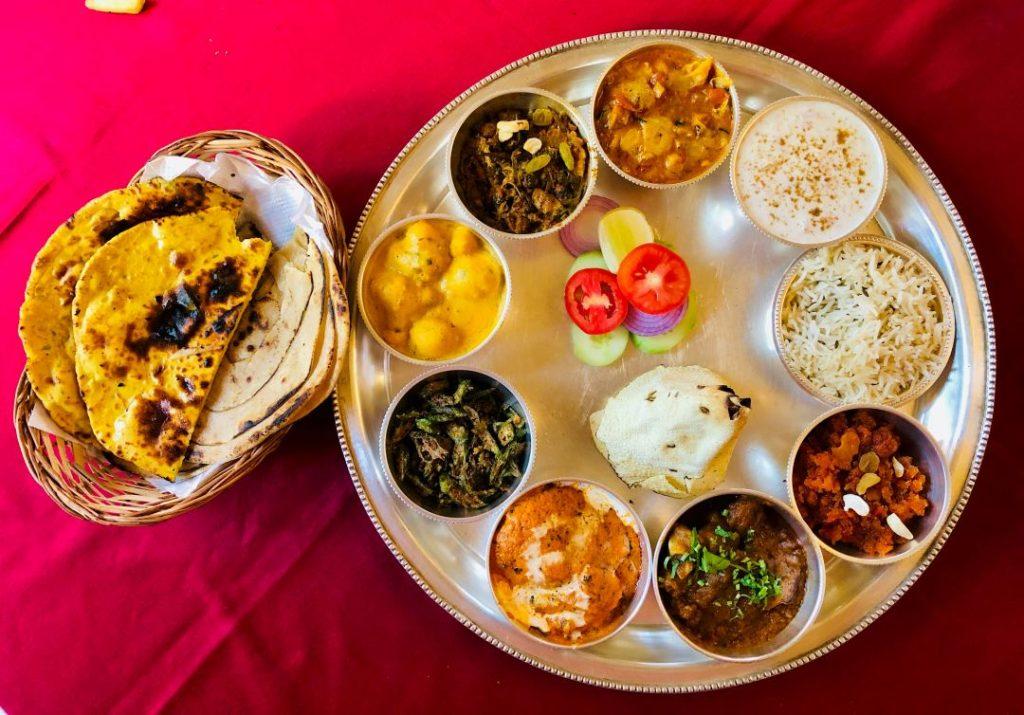 Best Nepalese food in Altrincham featuring a traditional Nepali thali with rice, curries, naan, papad, yogurt, and dessert.